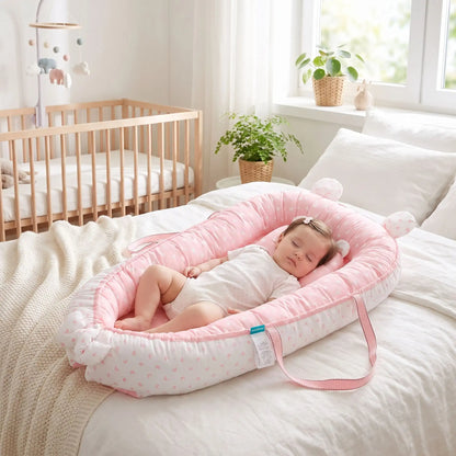 couffin bébé fille dort profondement dans reducteur sur lit adulte