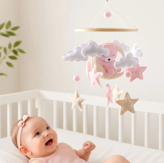 mobile-lit-bébé-heureux-regarde-ourson-rose